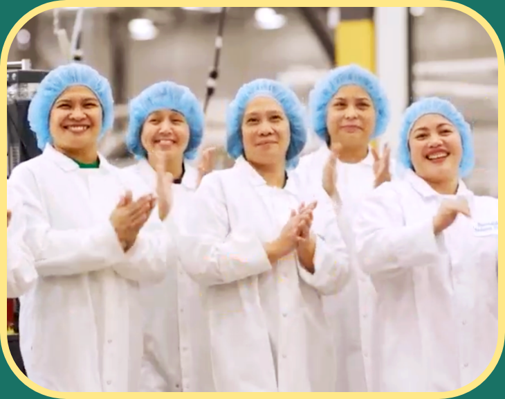 Group picture of production workers in lab coat at hair nets