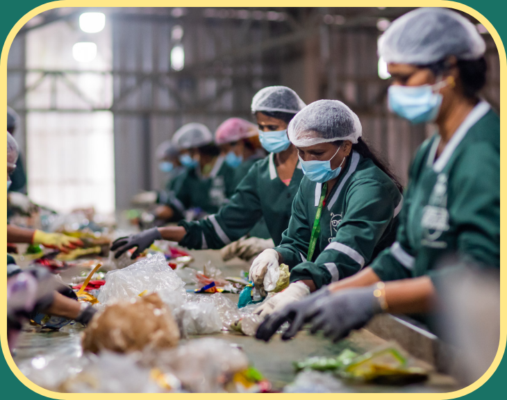 workers in PPE sorting waste on a conveyor belt