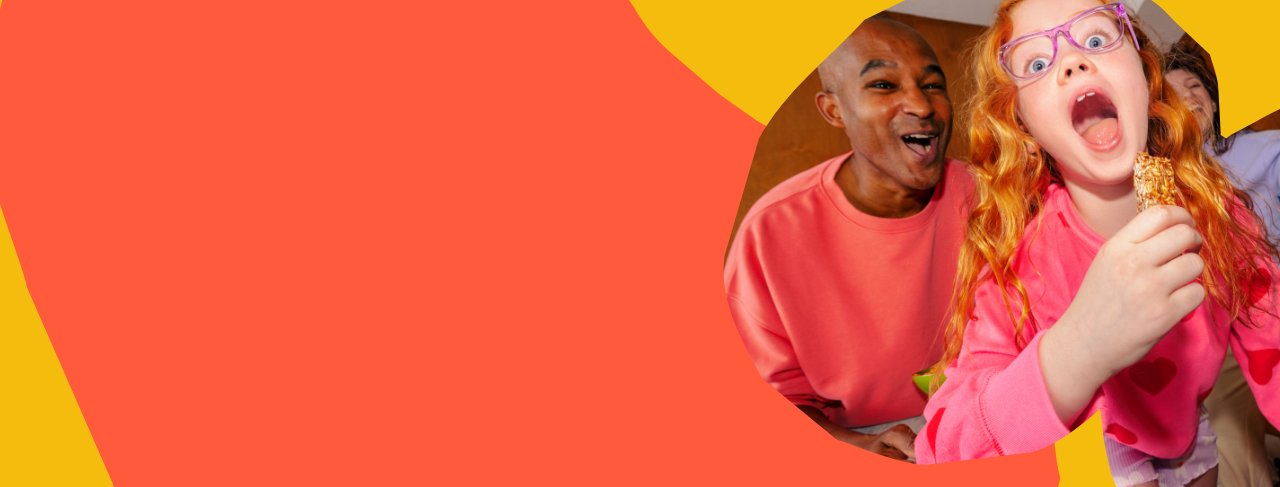 Child with red hair and pink glasses holding a granola bar against a colorful background abstract background
