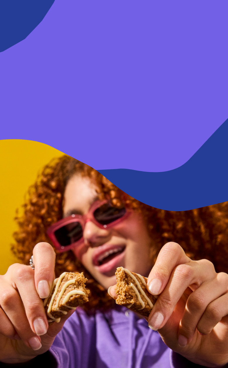 Woman holding two morning bars against a colorful abstract blue background.